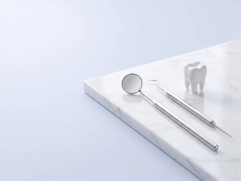 흰 대리석 위에 나란히 놓인 치과 거울과 탐침, 작은 치아 모형 (AI 생성 이미지)