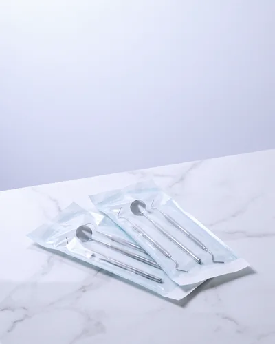 흰 대리석 위 밀봉된 멸균 파우치 두 개 (AI 생성 이미지)