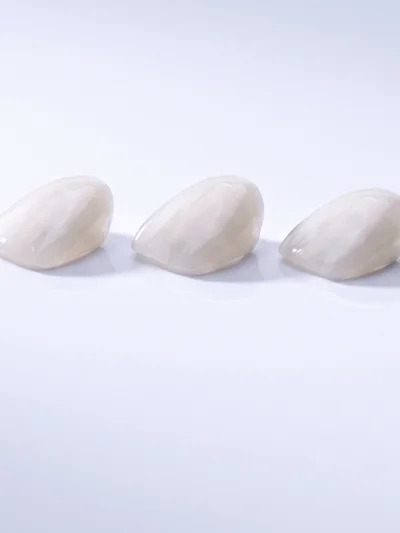 흰 바탕 위에 나란히 놓인 얇은 도자기 라미네이트 셸 세 장 (AI 생성 이미지)